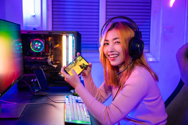 gamer playing online game application on mobile phone wear gaming headphones - 电竞 個照片及圖片檔