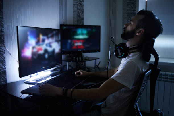 a young 30-year-old gamer is sitting at a computer, playing computer games, nervous, angry, worried.selective focus with low depth of focus - 电竞 個照片及圖片檔