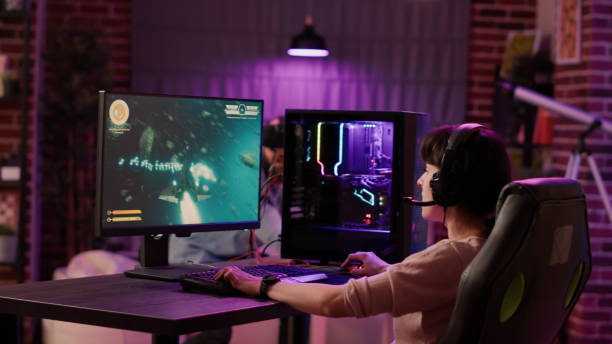 handheld shot of gamer girl celebrating winning first place in action space game while man is playing first person shooter - 电竞 個照片及圖片檔