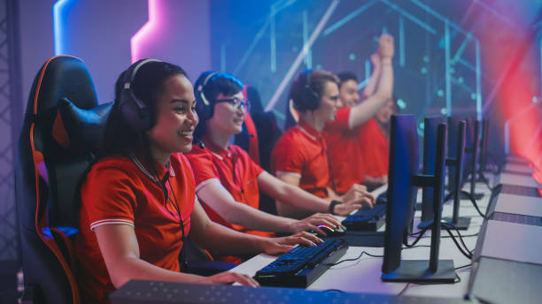 diverse esport team of pro gamers wearing headsets play in video game on a championship, win and celebrate with clapping. cyber games online streaming tournament arena. - 电竞选手 個照片及圖片檔