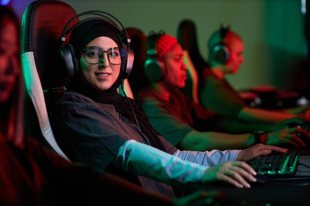 muslim woman playing video games and looking at camera - 电竞选手 個照片及圖片檔
