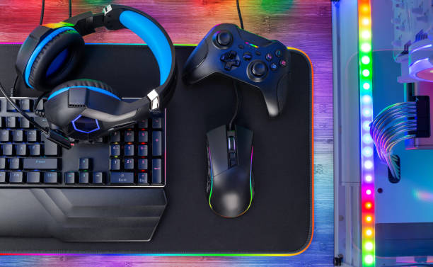top view of colorful bright pc rgb led gaming desk with headset keyboard mouse and desktop computer.  esports technology concept background - 电竞 個照片及圖片檔